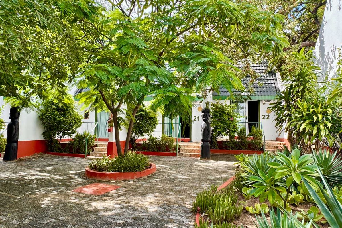 A landscaped courtyard area featuring paved walkways, mature trees, and access to hotel rooms numbered 21 and 22.