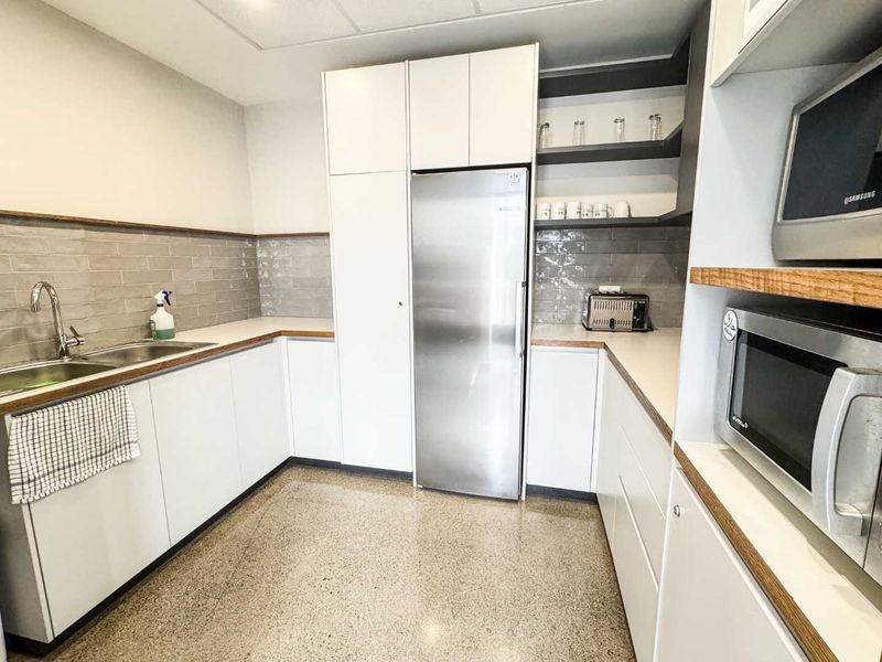 Modern kitchen featuring white cabinetry, stainless steel appliances, subway tile backsplash, and durable stone countertops in a clean, functional layout.