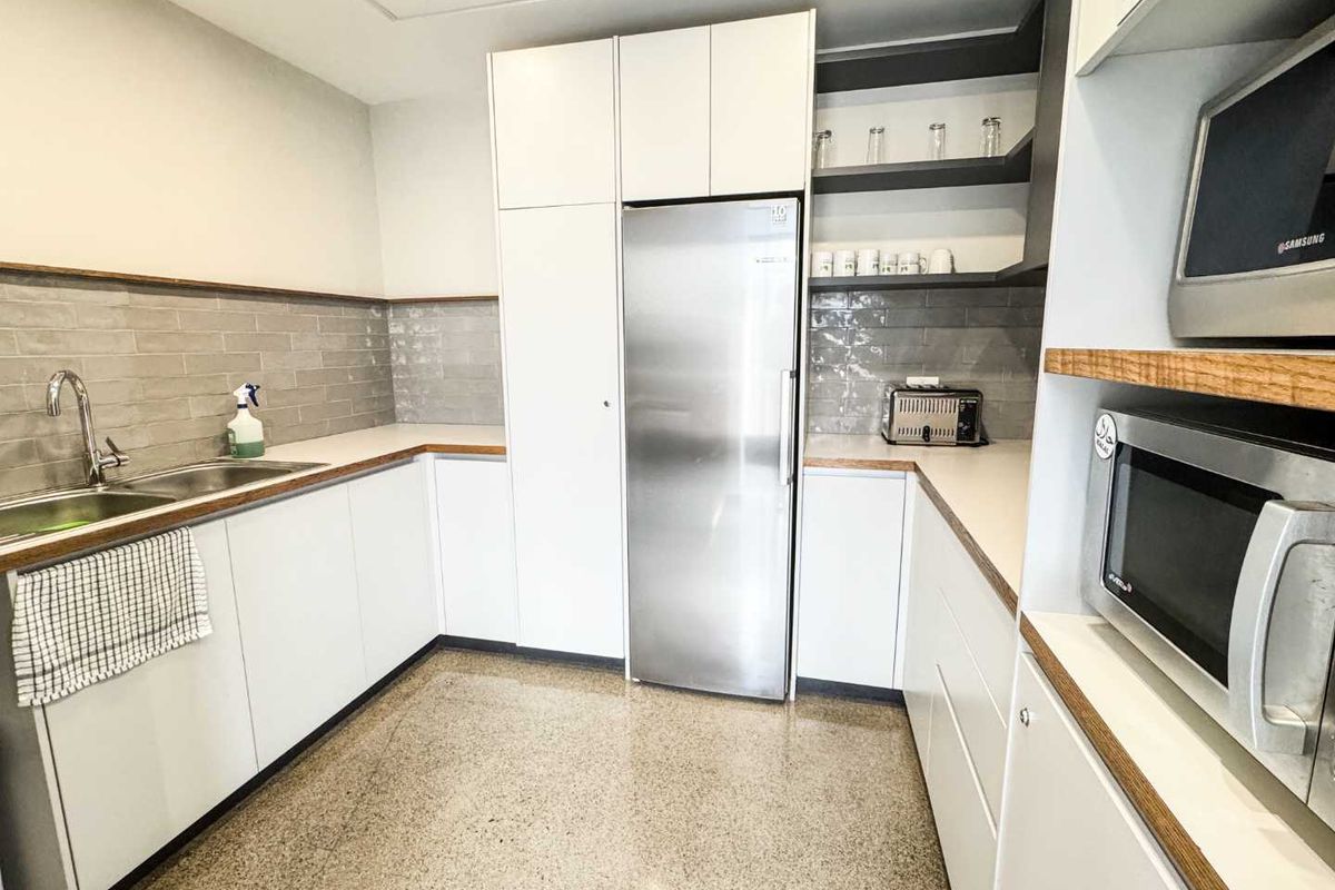 Modern kitchen featuring white cabinetry, stainless steel appliances, subway tile backsplash, and durable stone countertops in a clean, functional layout.