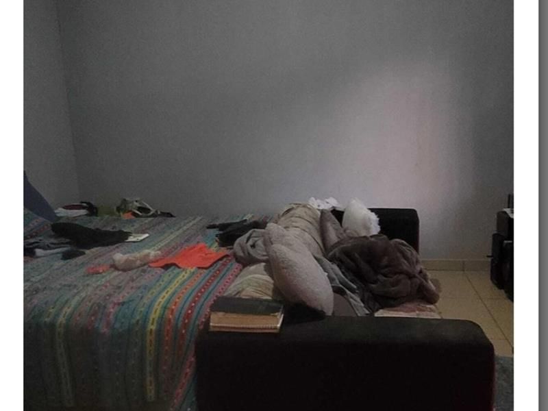 A bedroom featuring tiled flooring and coving, providing a functional space for rest.