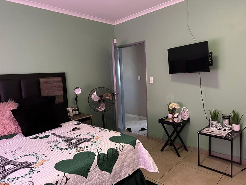 A bedroom featuring tiled flooring and coved ceilings, providing a functional space with neutral wall tones.