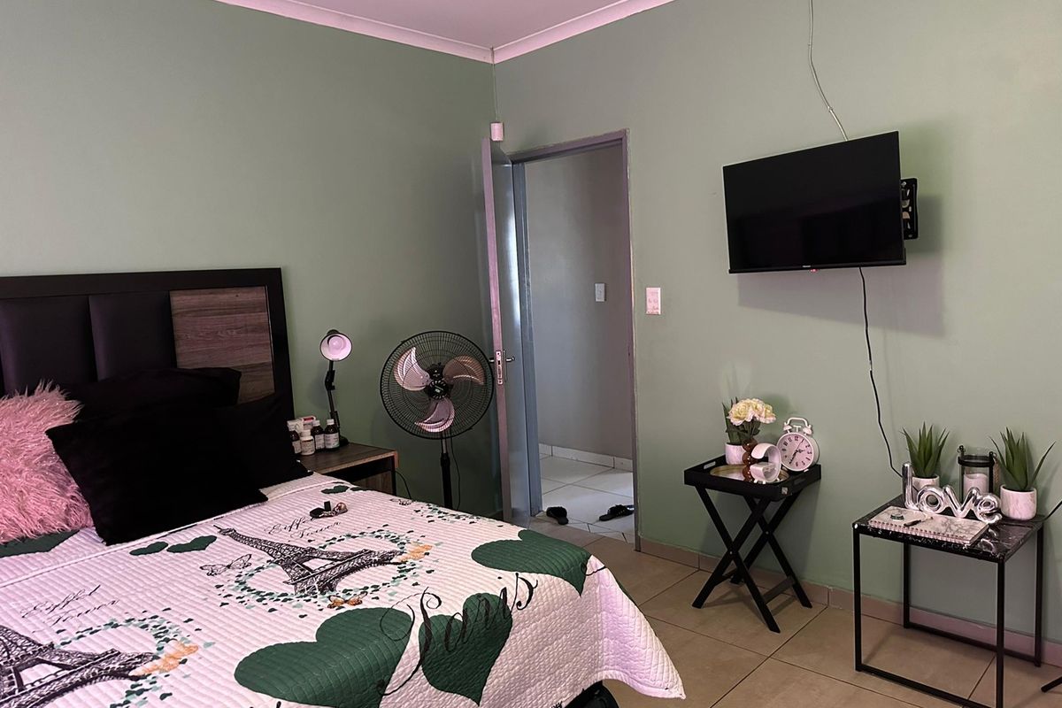 A bedroom featuring tiled flooring and coved ceilings, providing a functional space with neutral wall tones.