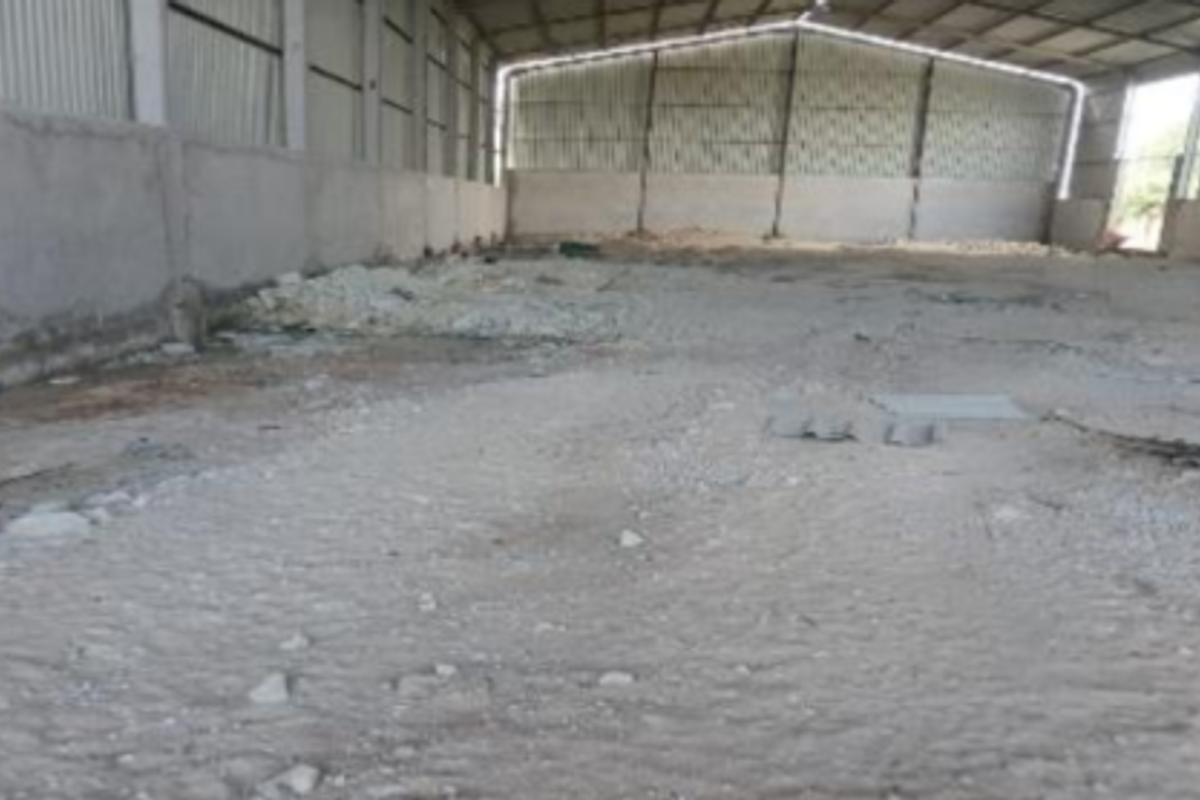 Large industrial warehouse space featuring a steel frame structure, corrugated metal roofing, and concrete perimeter walls, currently in a shell condition.