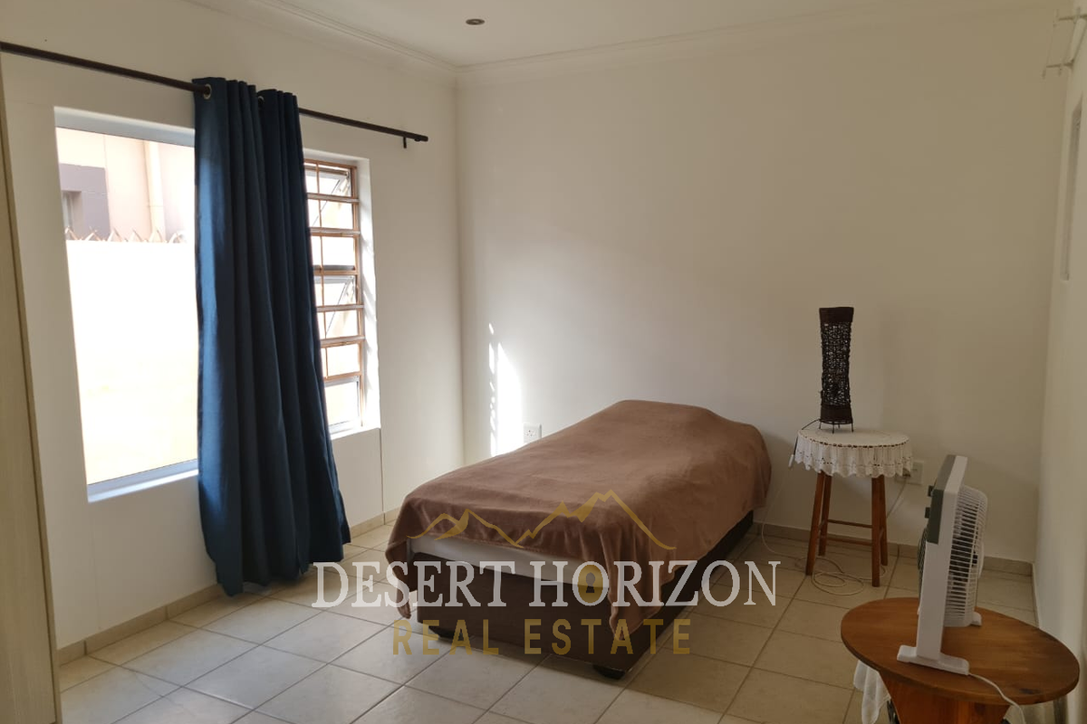 A bedroom featuring tiled flooring, a window with curtain rod, and recessed ceiling lighting.