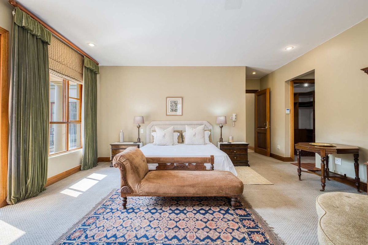 Spacious bedroom featuring neutral wall tones, carpeted flooring, recessed lighting, and direct access to an adjoining walk-in closet area.