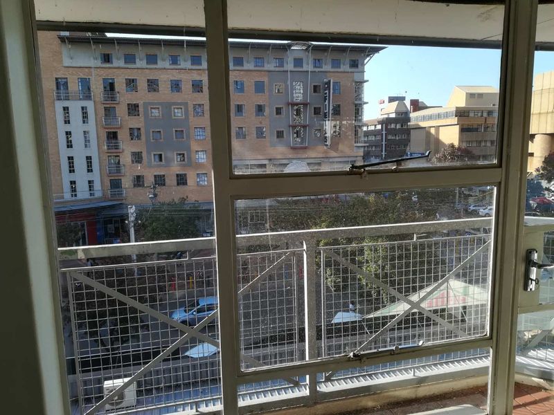 An urban view from an apartment window looking out over the surrounding city buildings and street level.