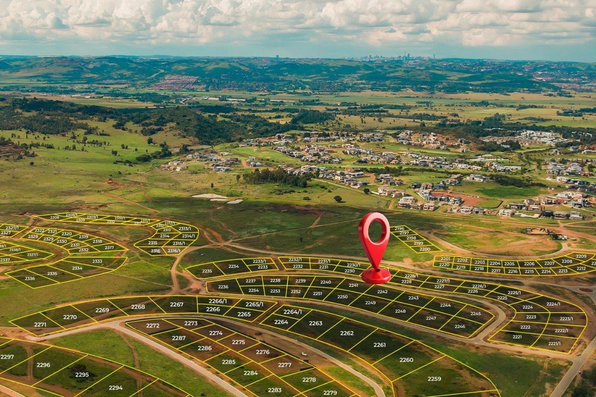 Aerial view of a residential land development estate showing demarcated plots and surrounding landscape.