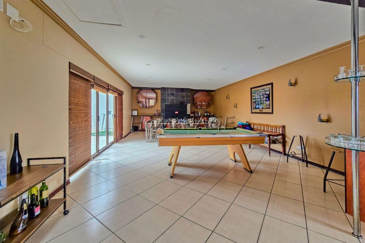 Spacious living area featuring tiled flooring, a built-in bar, and large sliding glass doors providing access to the outdoor space.