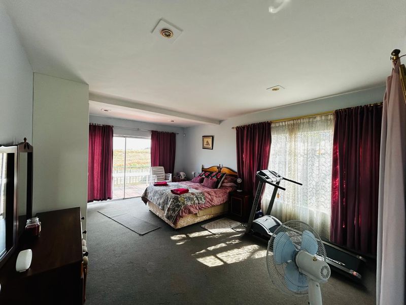 Spacious bedroom featuring carpeted flooring, recessed ceiling lighting, and large sliding glass doors providing access to an outdoor patio area.
