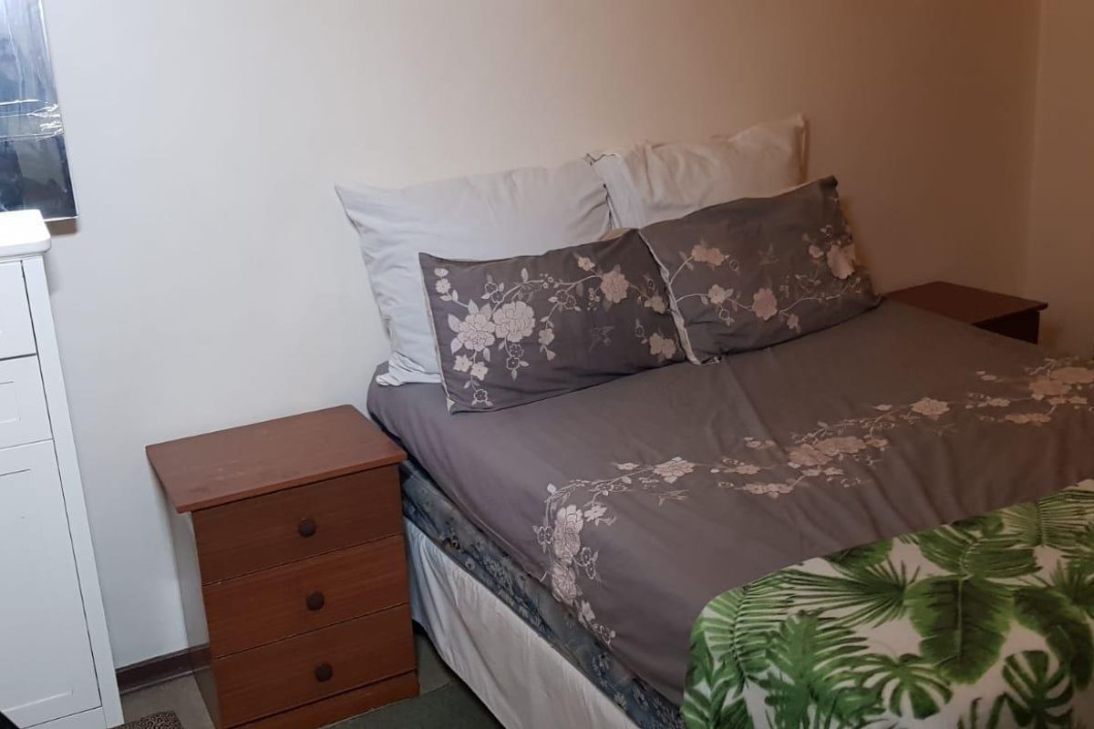 A standard bedroom featuring a built-in cupboard and neutral wall finishes, providing a functional sleeping space.