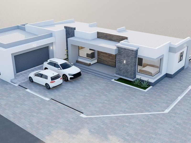 An aerial view of a modern residential property featuring a paved driveway, attached garage, and contemporary architectural design with stone accents.