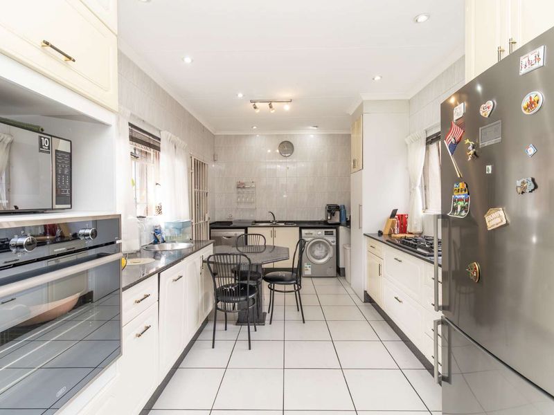 A well-maintained kitchen featuring built-in cabinetry, a gas hob, an integrated oven, and tiled finishes throughout, offering a functional and clean workspace.