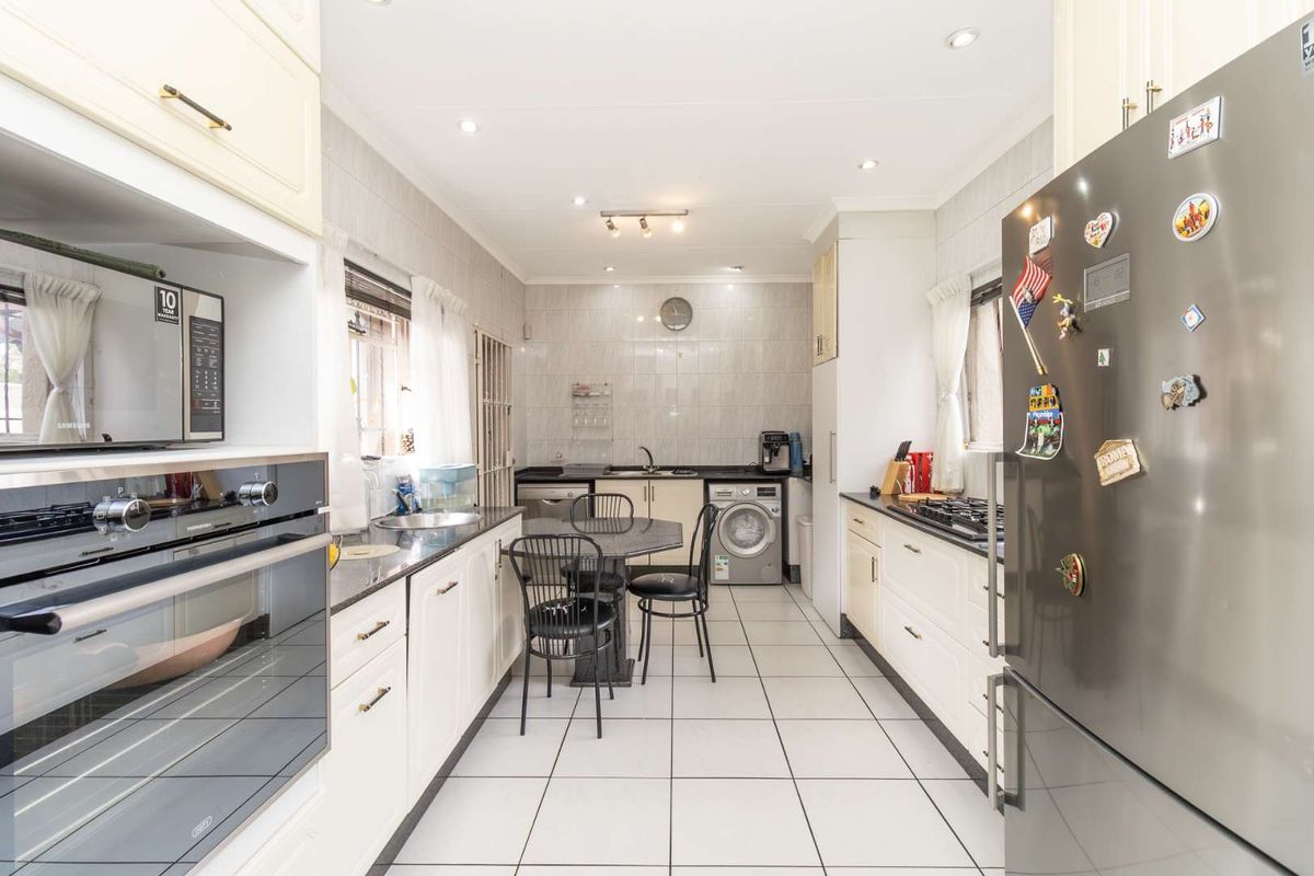 A well-maintained kitchen featuring built-in cabinetry, a gas hob, an integrated oven, and tiled finishes throughout, offering a functional and clean workspace.