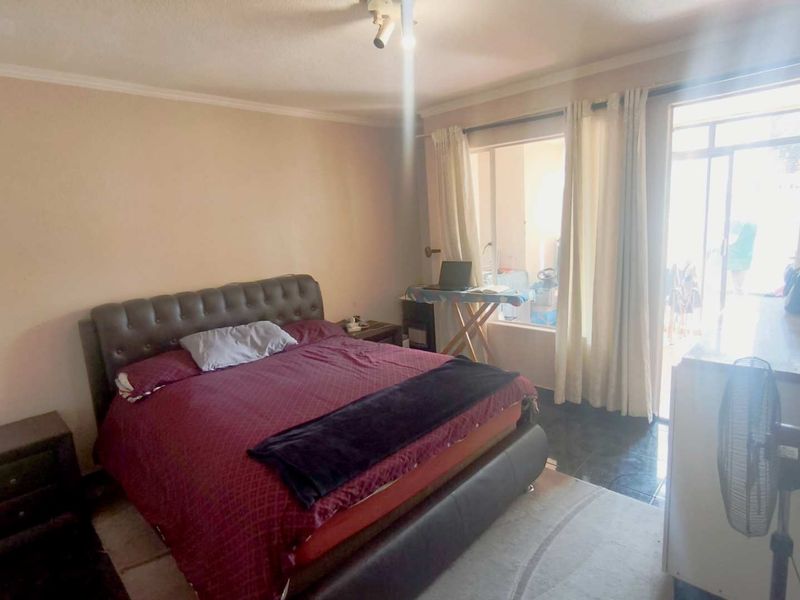 A bedroom featuring tiled flooring and a sliding glass door providing access to an outdoor area.