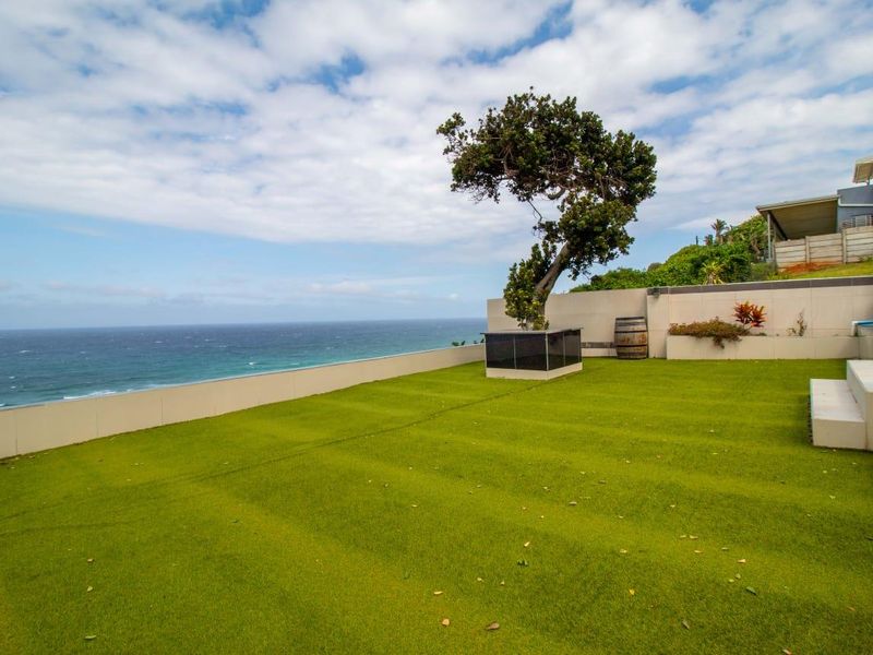 Spacious elevated terrace featuring artificial turf, built-in planter boxes, and panoramic ocean views, providing an ideal outdoor entertainment space.