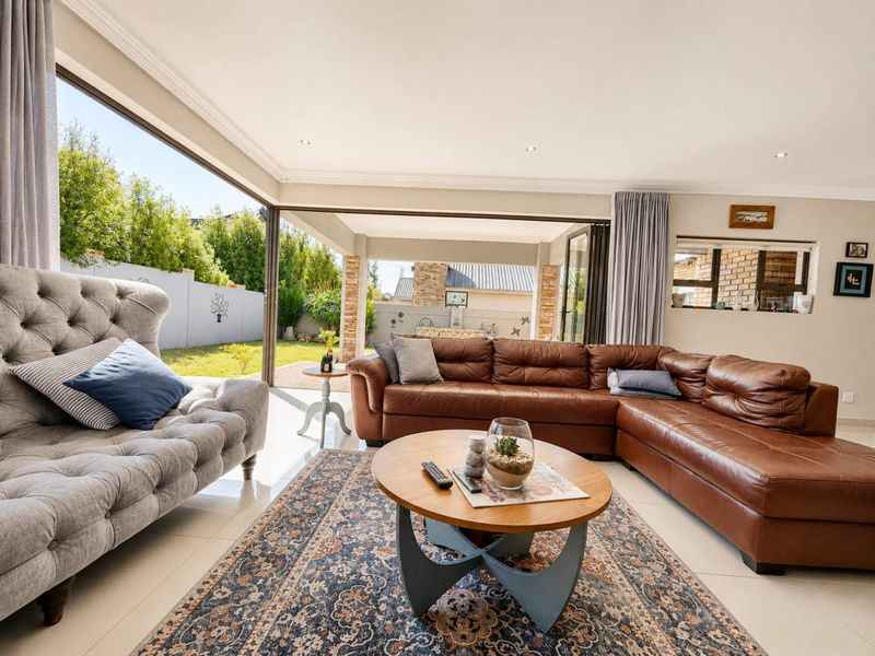 Spacious living room featuring large sliding glass doors that open to an outdoor patio, tiled floors, and recessed lighting.