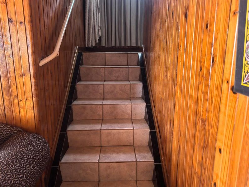 A staircase featuring tiled steps and timber wall paneling, providing a functional transition between levels.
