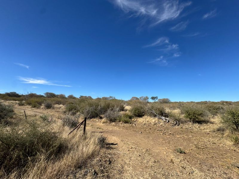 An expansive view of the natural veld landscape on the small holding, featuring dry vegetation and existing wire boundary fencing.