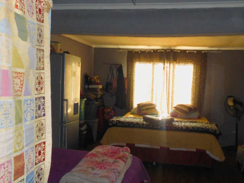 A bedroom space featuring a window with curtain rails and basic interior finishes.