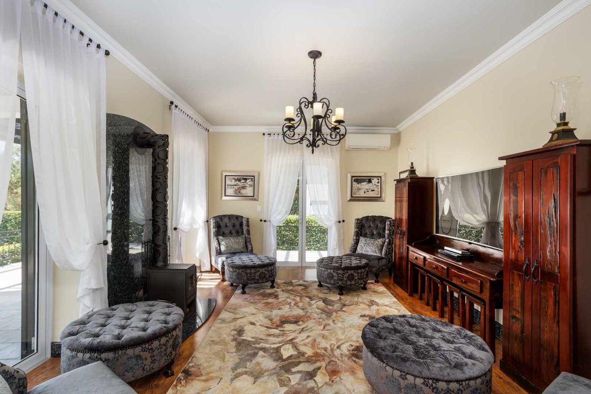 A well-maintained living room featuring a cast iron fireplace, crown molding, and direct access to the outdoor area through glass sliding doors.