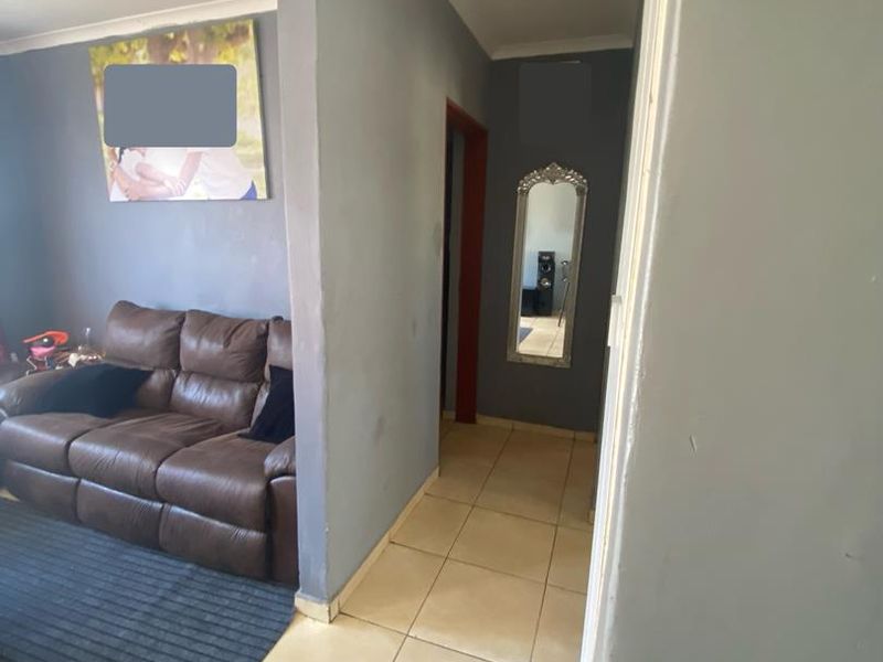 A functional hallway featuring tiled flooring and coved ceilings, connecting the living area to other parts of the apartment.