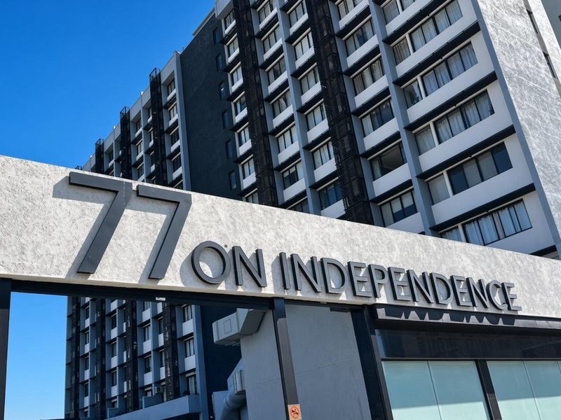 Exterior view of the 77 on Independence apartment building, showcasing its modern multi-story facade and prominent signage.