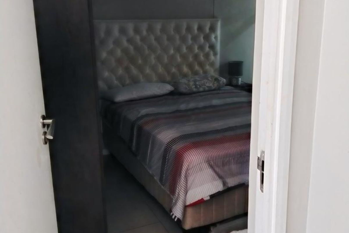 A view into a bedroom featuring tiled flooring, captured through an open doorway.