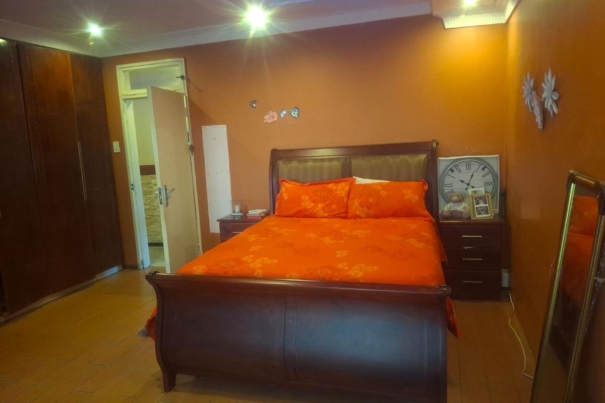 A bedroom featuring built-in cupboards, tiled flooring, and recessed ceiling lighting.