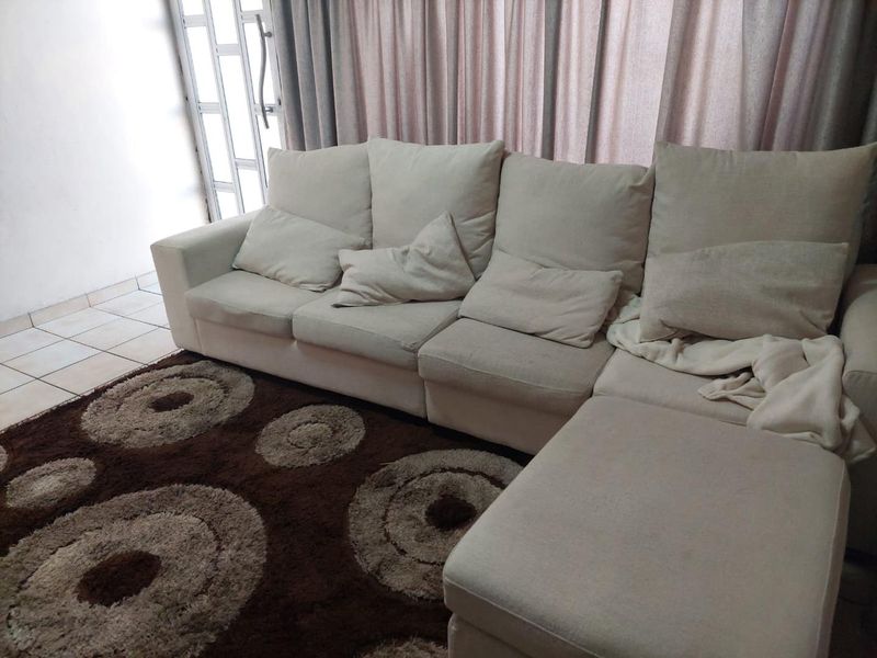 A living room area featuring tiled flooring and a security gate leading to the exterior.