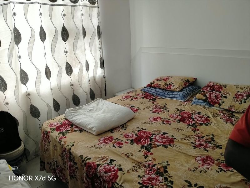 A bedroom featuring a built-in headboard and natural light from the window.