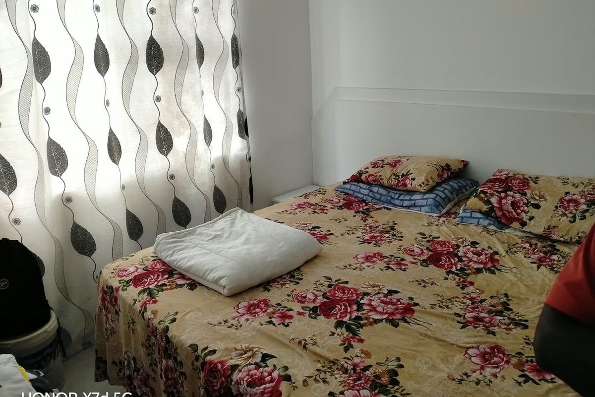 A bedroom featuring a built-in headboard and natural light from the window.