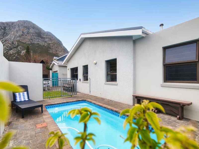 A private swimming pool area featuring a paved deck, boundary wall, and mountain views, providing a functional outdoor space for relaxation.