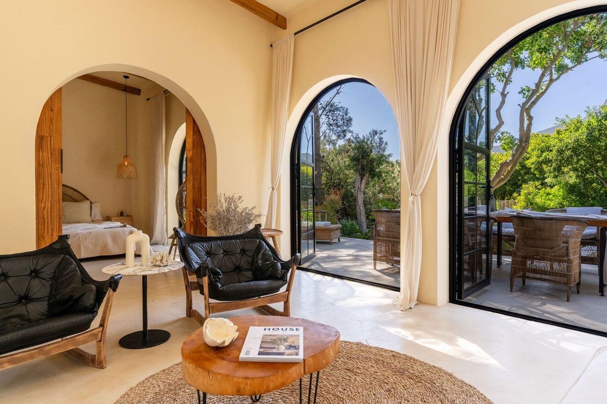 A bright living area featuring elegant arched doorways that open onto a lush garden patio, seamlessly connecting indoor and outdoor living spaces.
