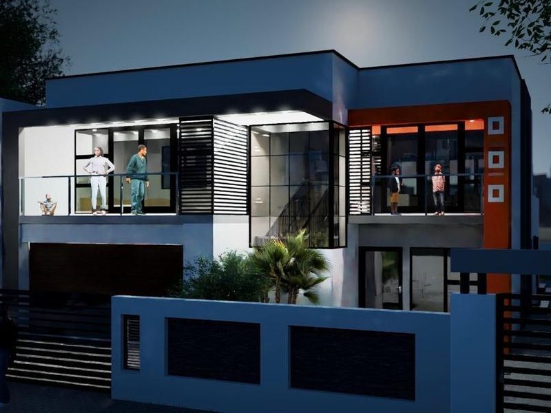A modern two-story residential facade featuring a balcony with glass balustrades, slatted privacy screens, and a secure boundary wall at night.