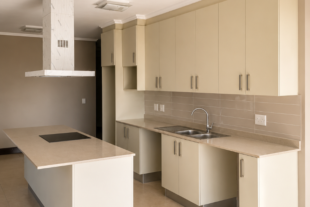Modern, clean kitchen featuring a central island, stone countertops, ample built-in cabinetry, and integrated appliances, finished with neutral tiling throughout.