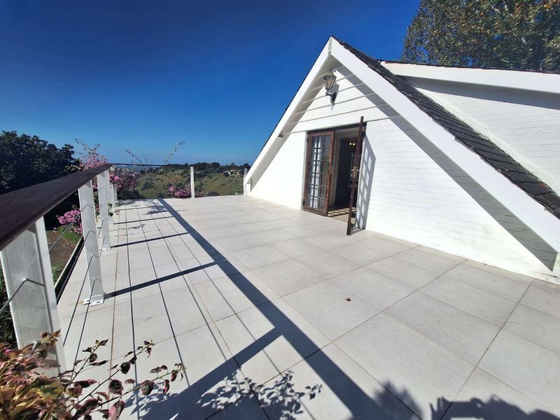 Spacious balcony featuring tiled flooring, a protective railing, and direct access to the interior through classic french doors with scenic views.