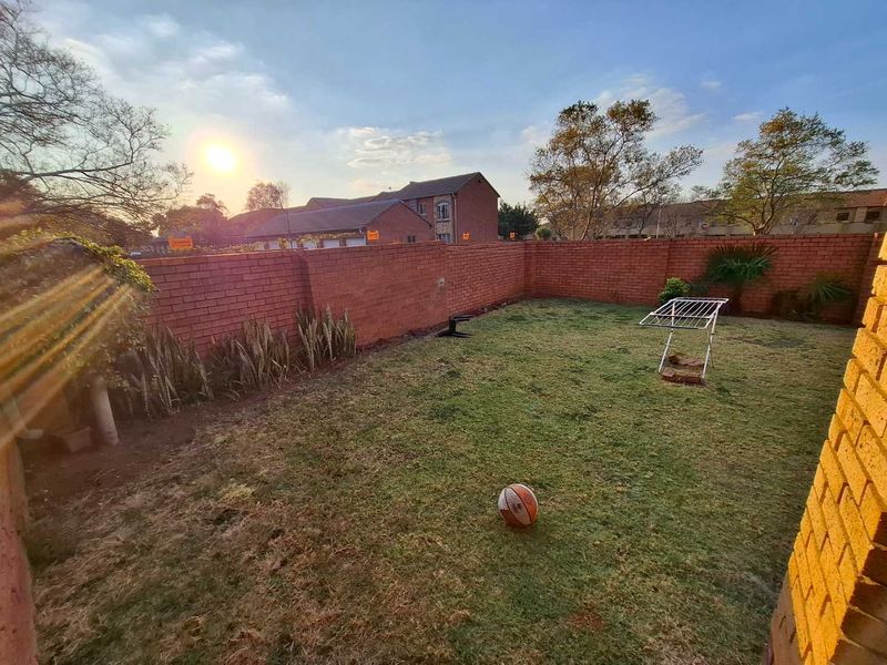 A private rear garden area enclosed by a brick boundary wall with a lawn space.
