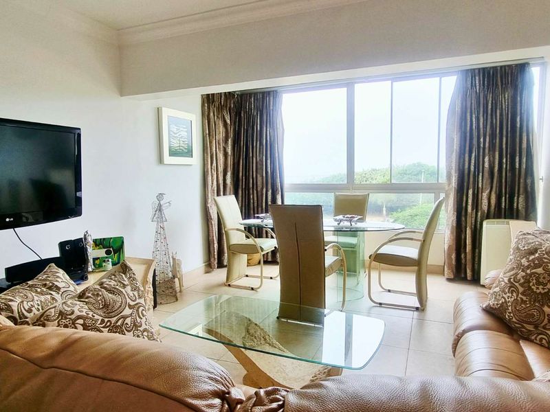 Open plan living and dining area featuring large sliding windows that provide natural light and views.
