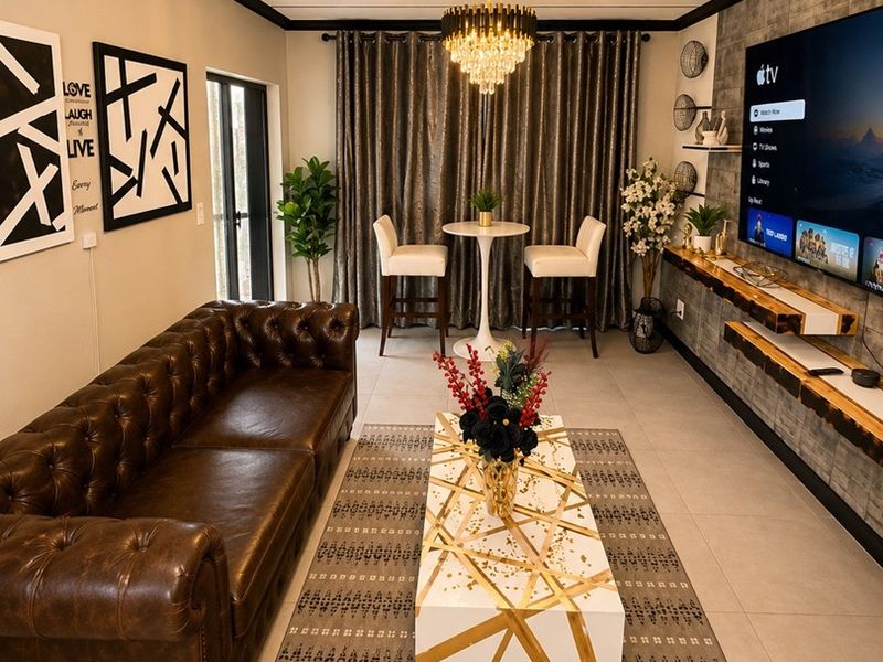 A modern living room featuring a stone accent wall with a built-in floating media console, tiled flooring, and elegant ceiling trim.