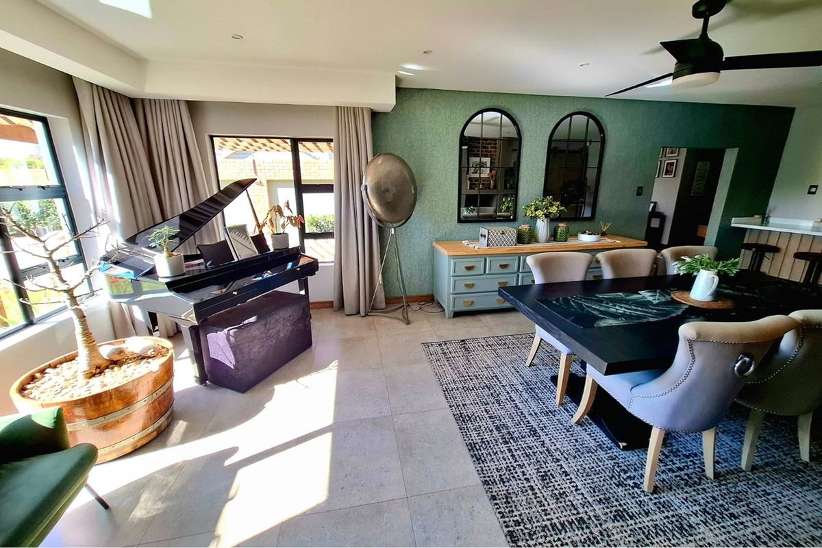 Spacious living and dining area featuring large windows, tiled flooring, recessed lighting, and a ceiling fan, creating a bright and inviting atmosphere.