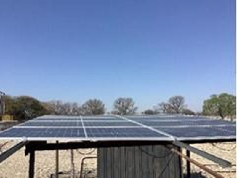 A ground-mounted solar panel array installed on a metal support structure, providing renewable energy infrastructure for the farm property.