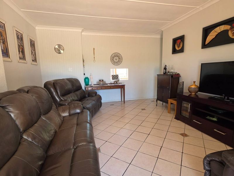 A comfortable living room featuring tiled flooring and coved ceilings, providing a functional and neutral space for relaxation.