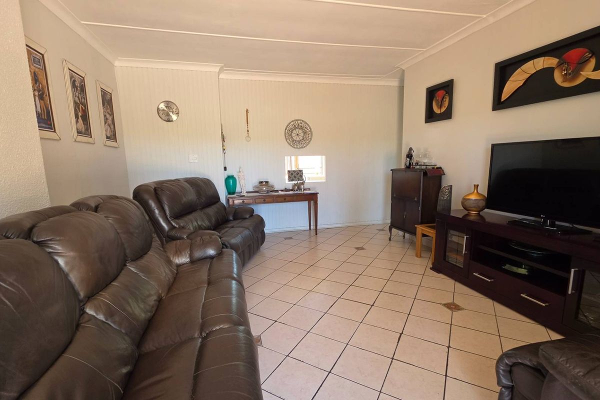 A comfortable living room featuring tiled flooring and coved ceilings, providing a functional and neutral space for relaxation.