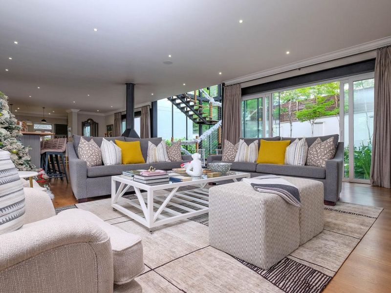 Spacious open-plan living area featuring hardwood floors, a modern fireplace, and large sliding glass doors that provide seamless access to the outdoor space.