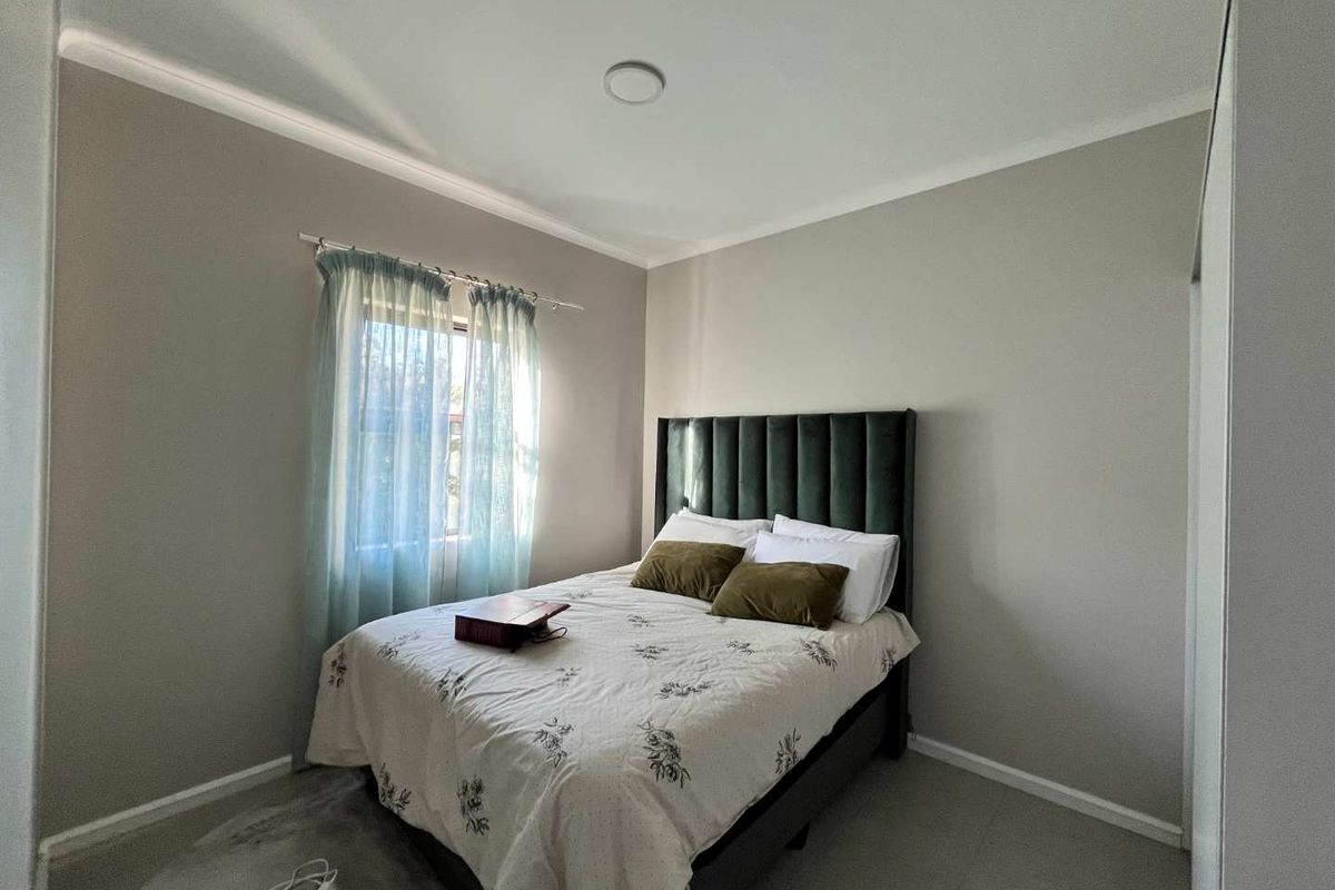 A well-maintained bedroom featuring neutral wall tones, cove cornicing, and a built-in wardrobe, offering a clean and functional living space.