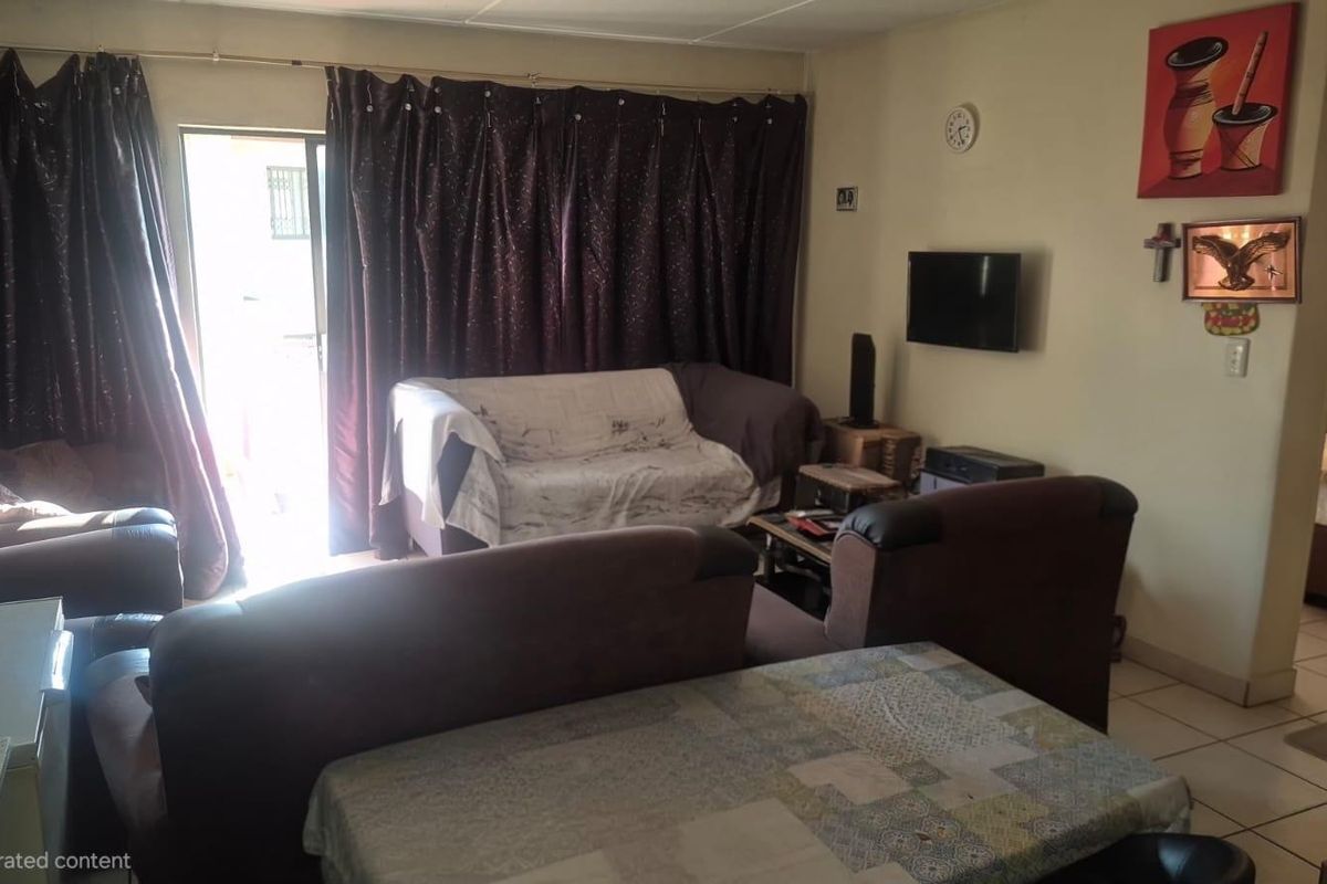A living room area featuring tiled flooring and a sliding glass door providing access to the exterior.