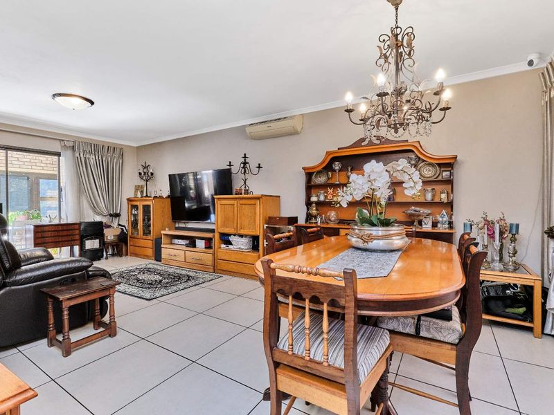 Spacious open-plan living and dining area featuring tiled flooring, split-system air conditioning, and direct access to the outdoor patio through sliding glass doors.