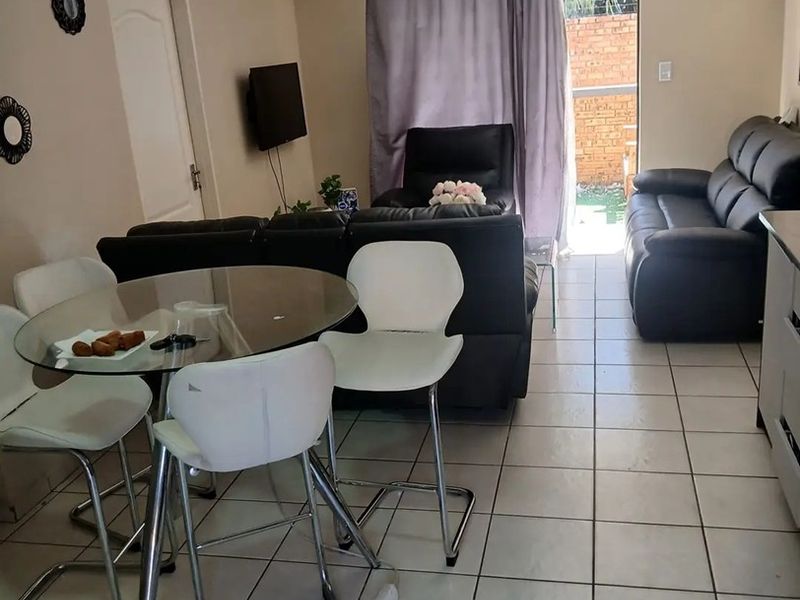 Open plan living and dining area featuring tiled flooring and direct access to an outdoor space through a sliding door.