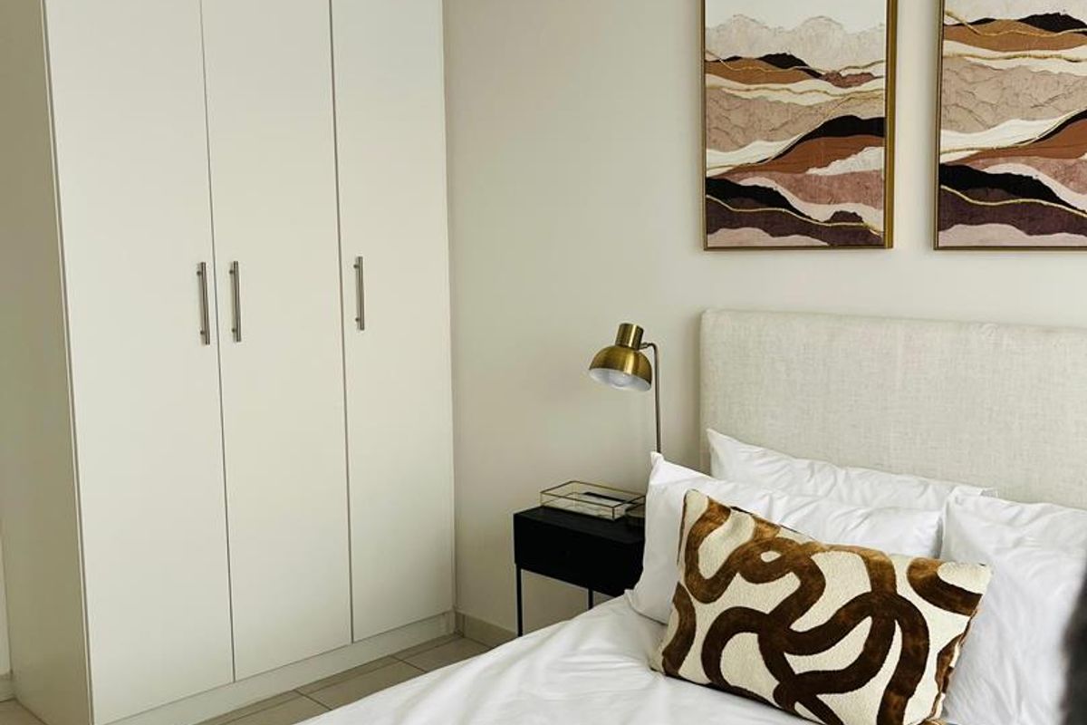 A well-maintained bedroom featuring a built-in wardrobe and neutral tiled flooring, offering a clean and functional living space.
