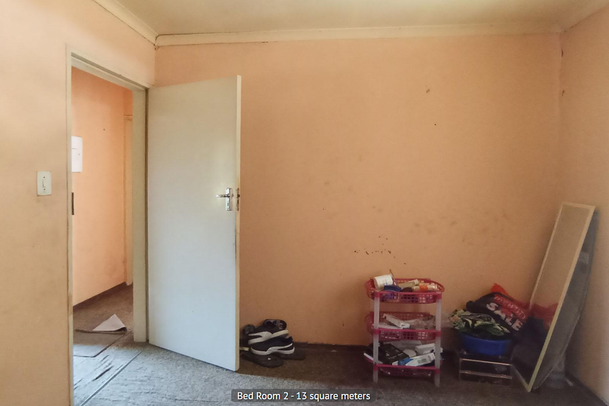 A bedroom featuring peach-toned walls and carpeted flooring, providing a blank canvas for potential renovation or restyling.